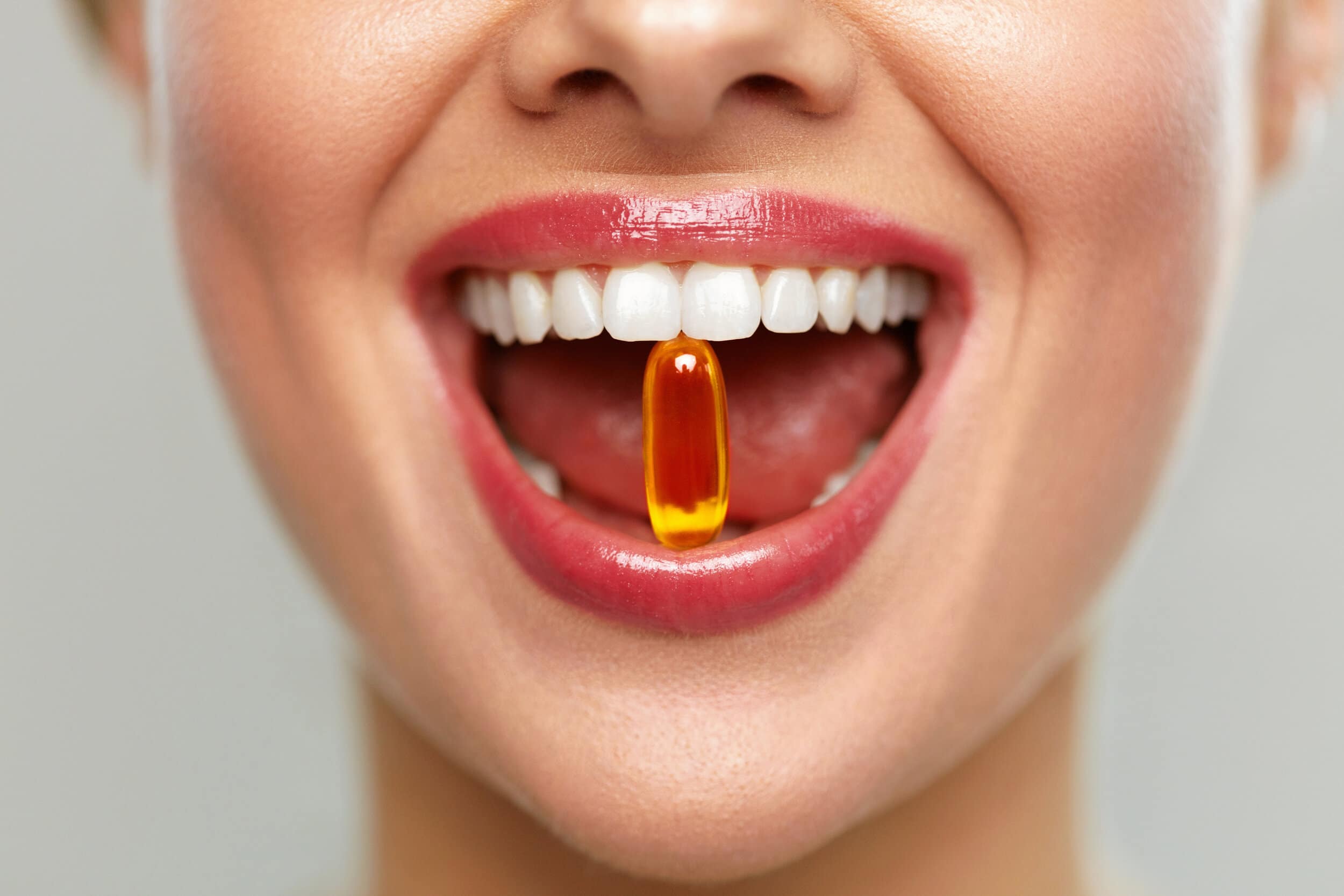 Woman with pill in teeth