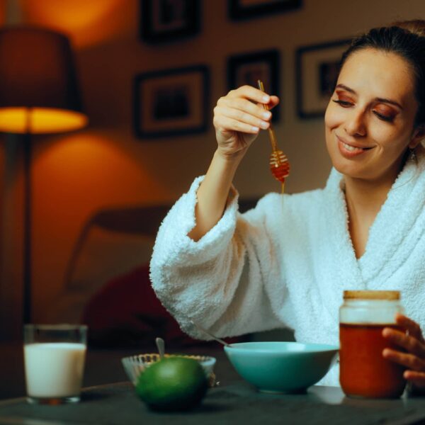 Woman Using Homemade Natural Honey Facial Treatments. Lady making her own face mask at hone with organic ingredients