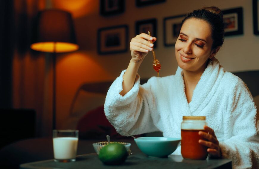 Woman Using Homemade Natural Honey Facial Treatments. Lady making her own face mask at hone with organic ingredients