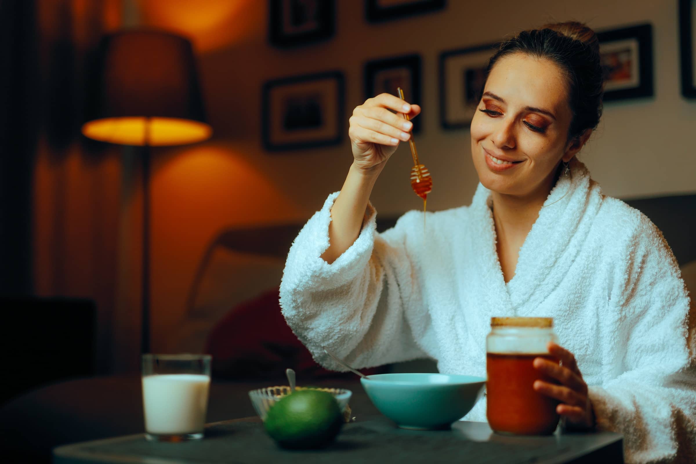 Woman Using Homemade Natural Honey Facial Treatments. Lady making her own face mask at hone with organic ingredients