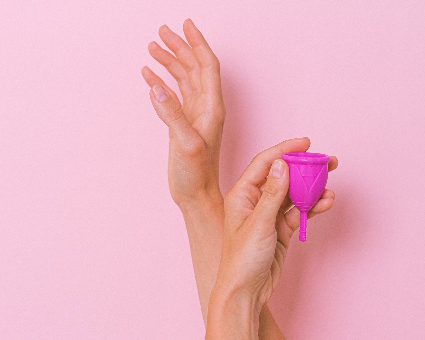 Hands hold up menstrual cup