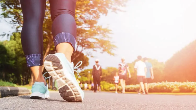 Young fitness woman legs walking with group of people
