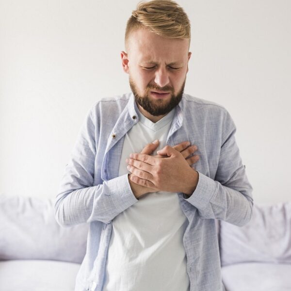 man holds hands across chest in pain