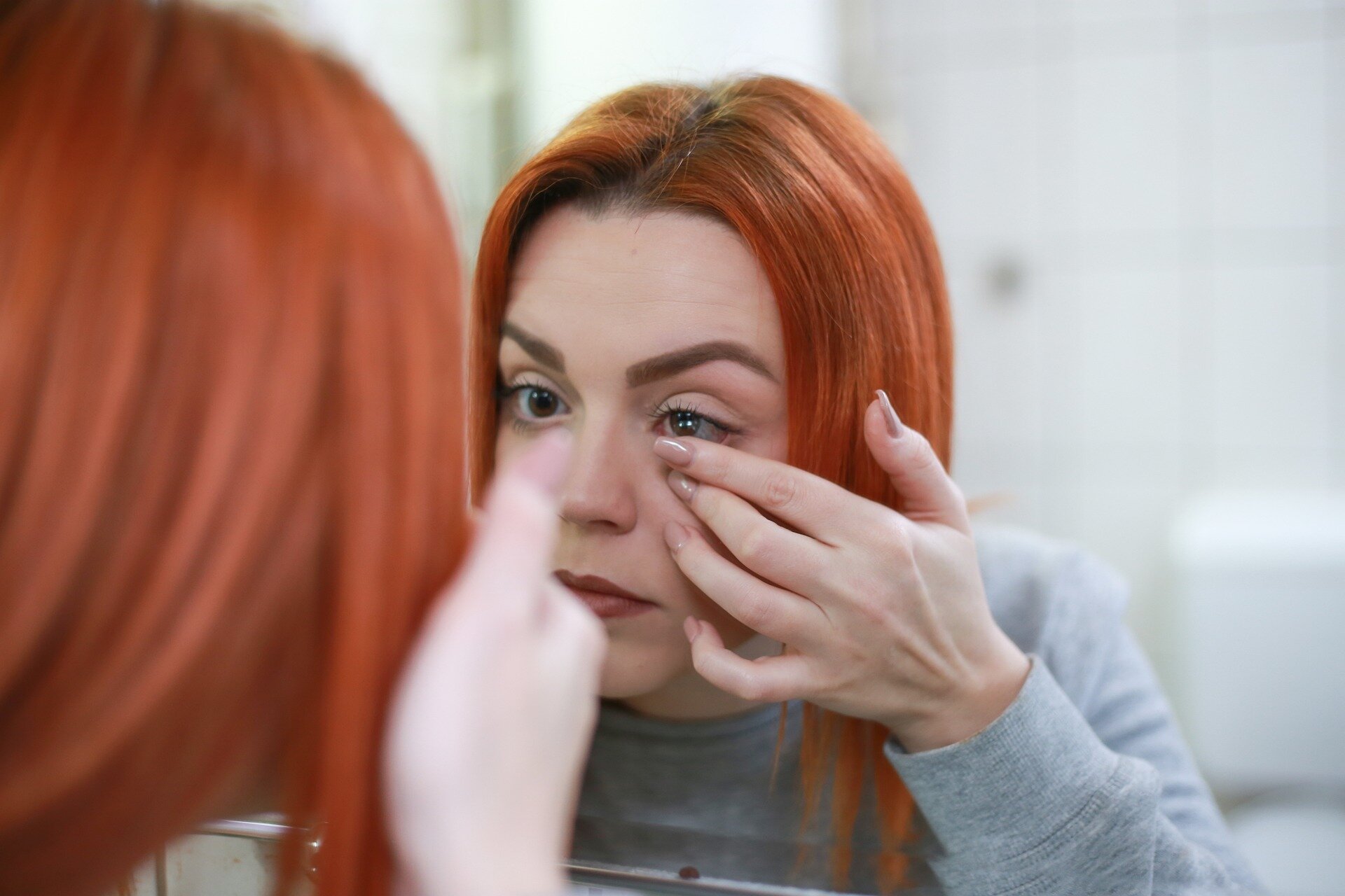 woman putting contact lenses in eye