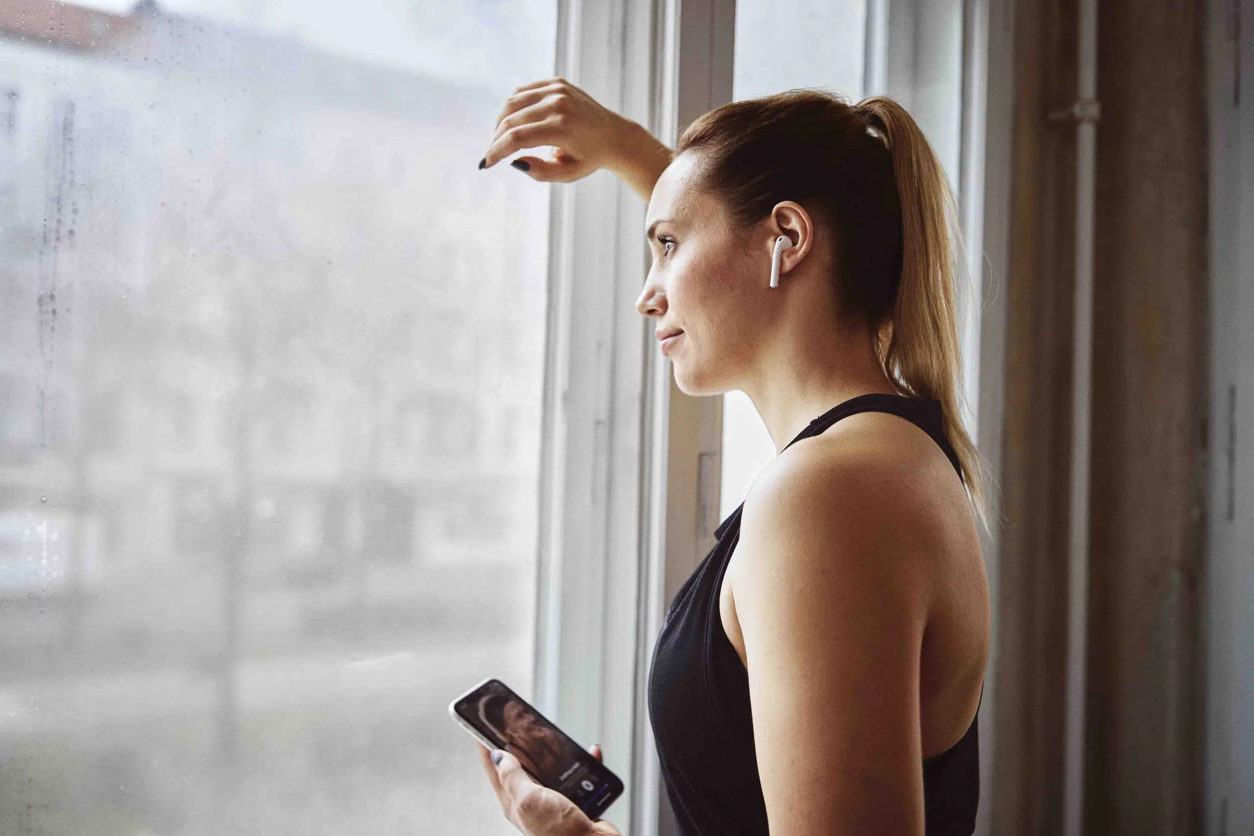 Freeletics woman looks out from window scaled