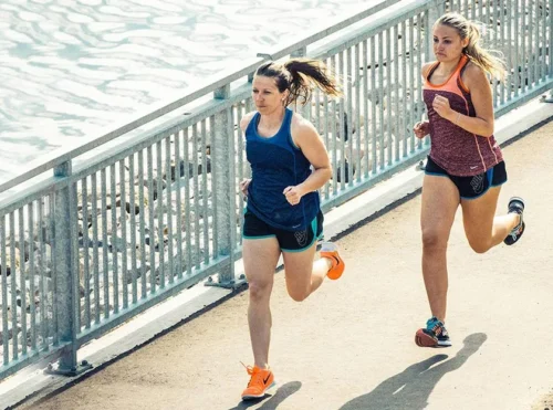 Runners run across path near river