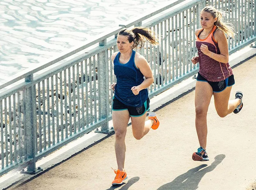Runners run across path near river