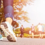 Young fitness woman legs walking with group of people