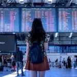 person looking at airport arrivals board