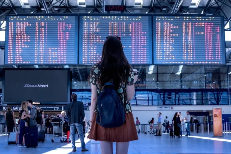 person looking at airport arrivals board