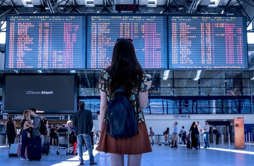 person looking at airport arrivals board