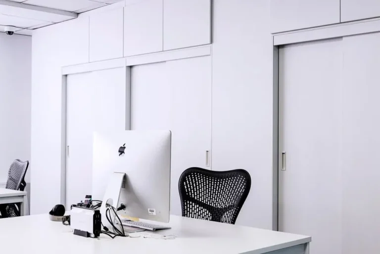 black mesh office rolling chair beside white wooden desk 217294