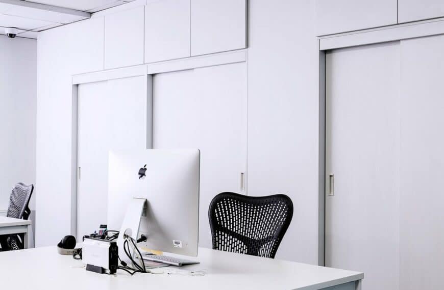 black mesh office rolling chair beside white wooden desk 217294