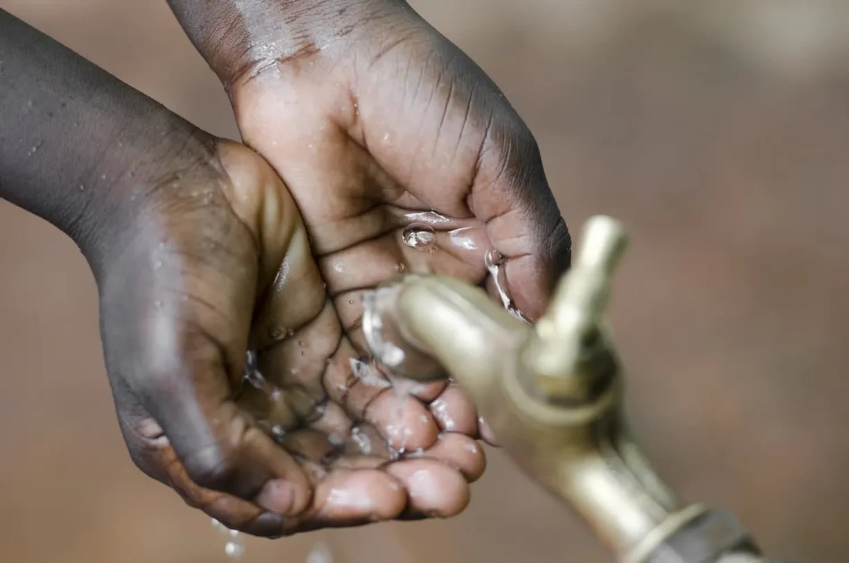 hands being washed under outside tap