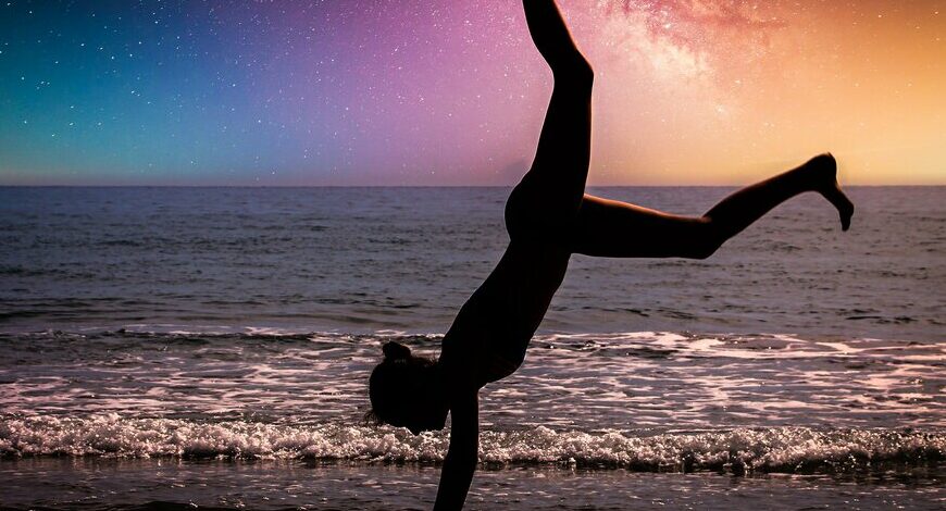 woman cartwheels with night sky in view