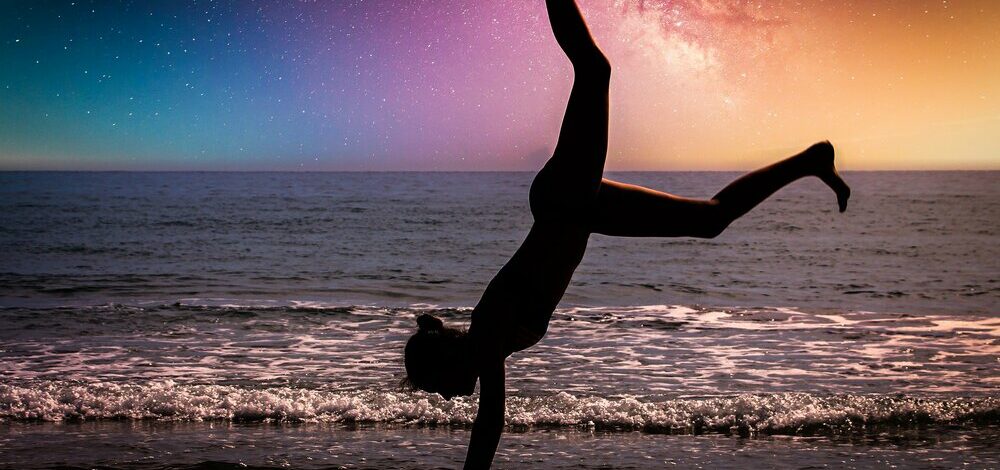 Woman cartwheels with night sky in view