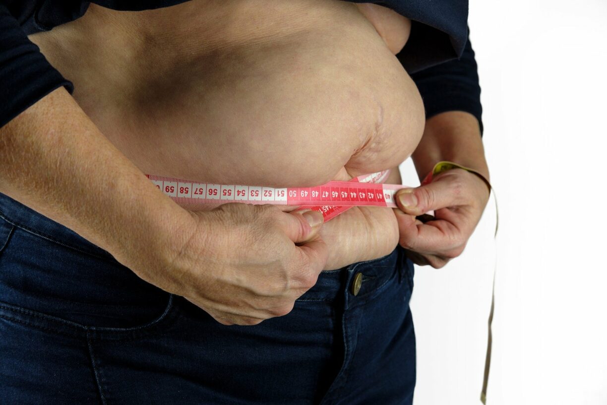 Person putting tape measure around their waist
