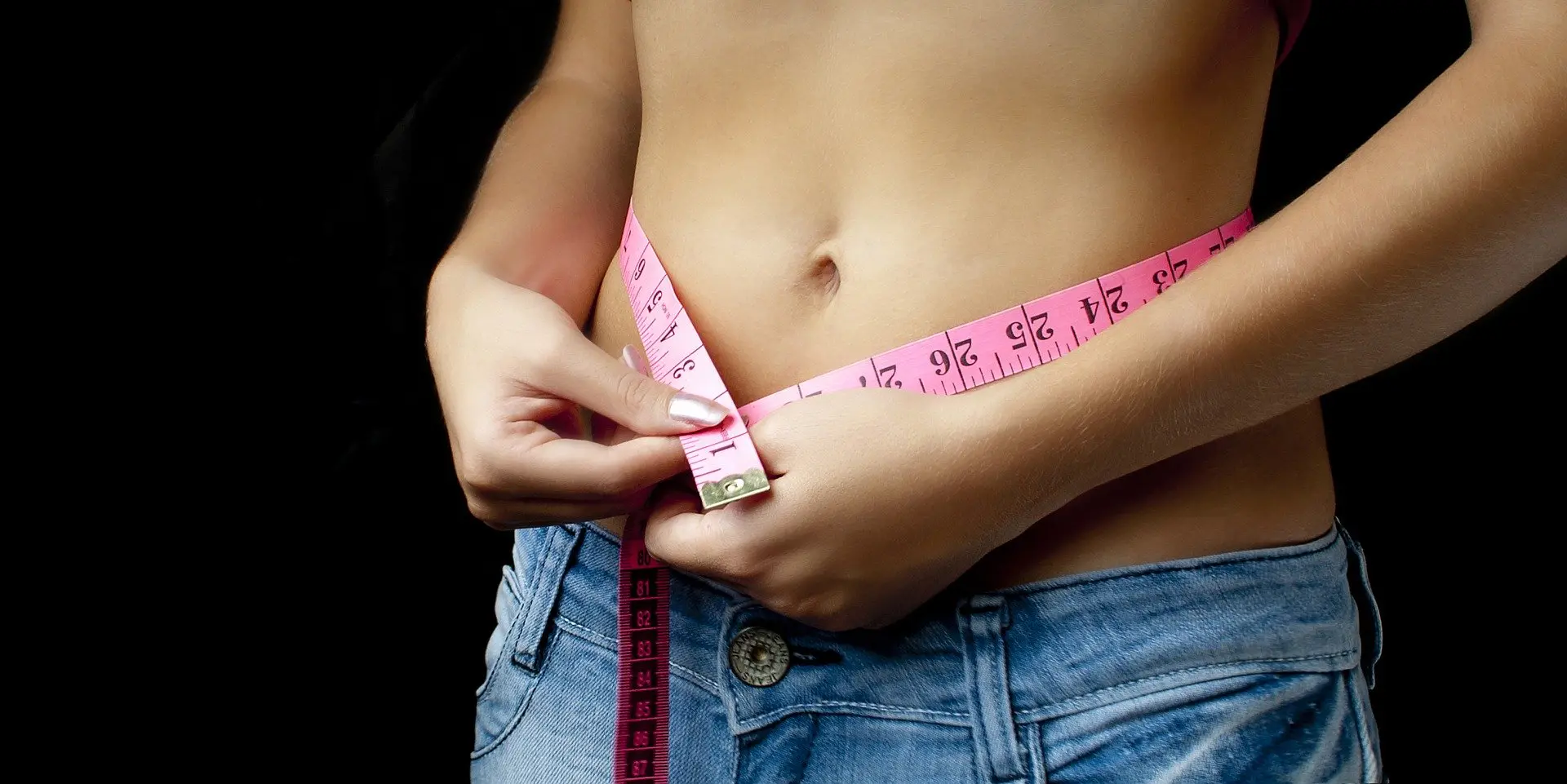 Woman measures her waistline