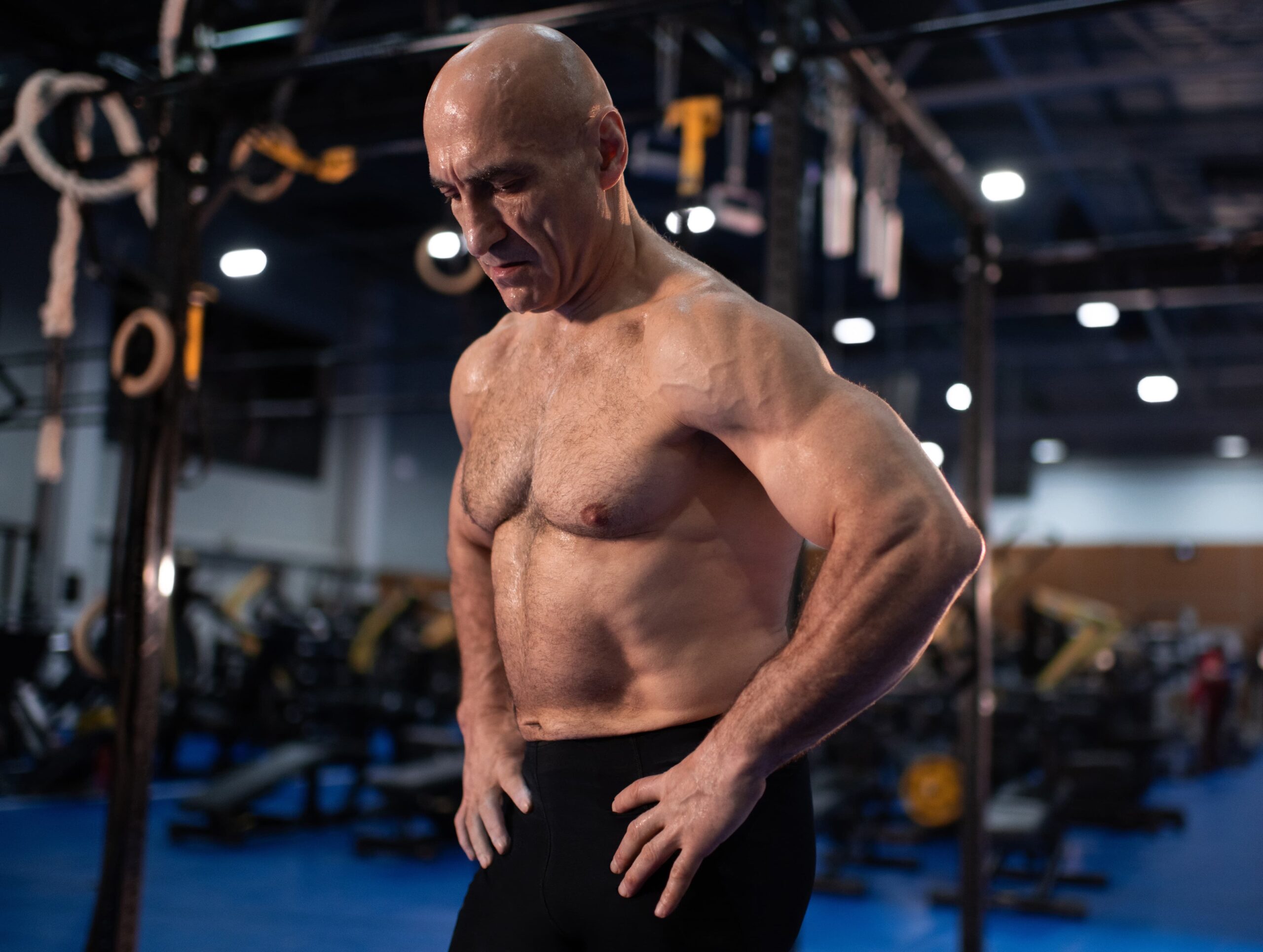 Muscular aged man resting during functional workout 1 scaled