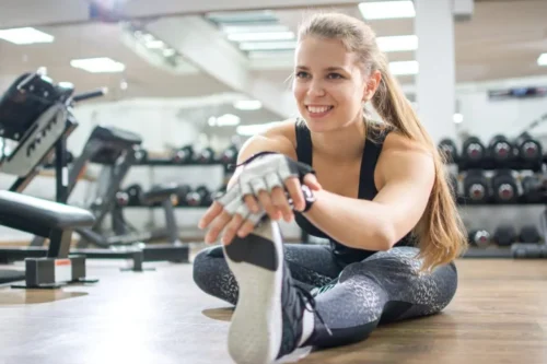 fitness woman stretches leg e1612736636220