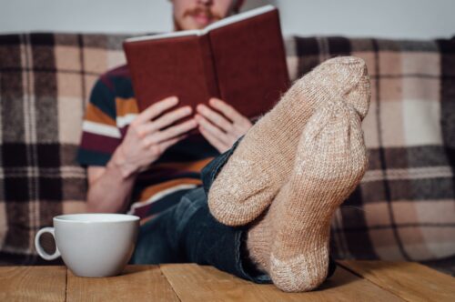 man with feet up reading a book scaled