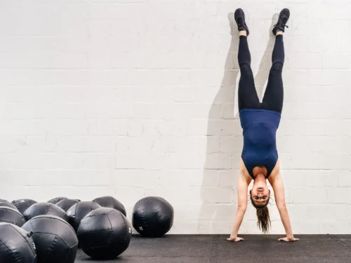 woman doing handstand against the wall