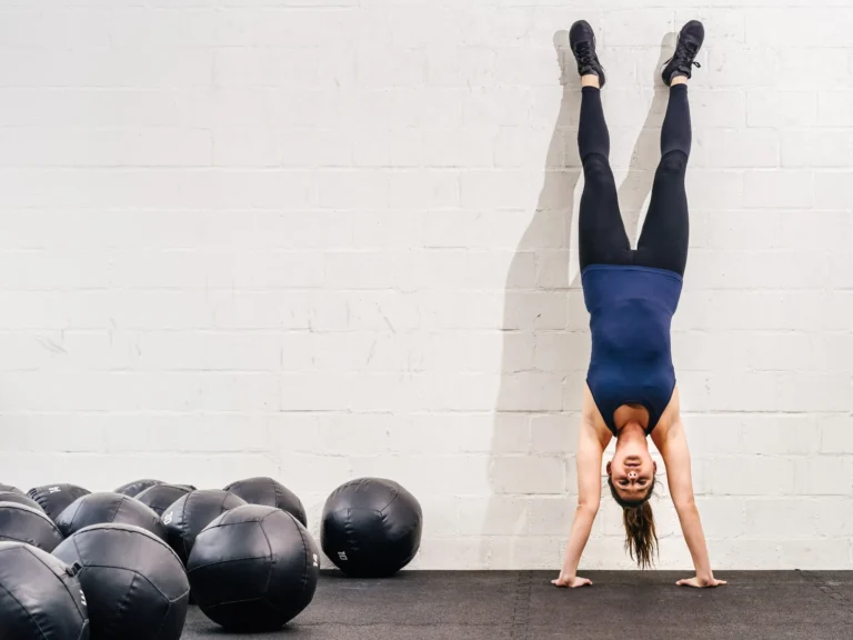 woman doing handstand against the wall