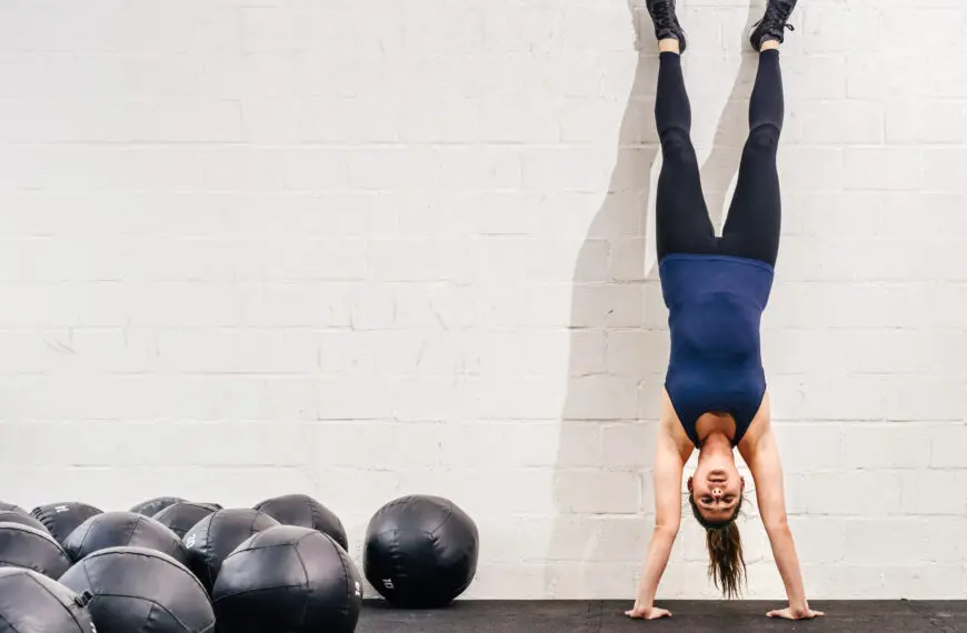 woman doing handstand against the wall
