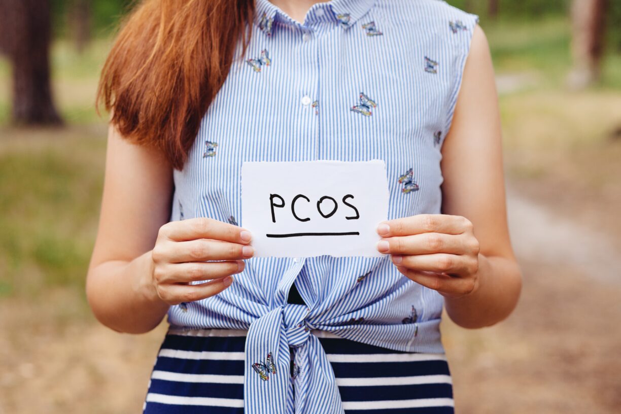 woman holds pcos sign scaled