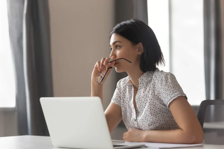 woman looks anxious over laptop