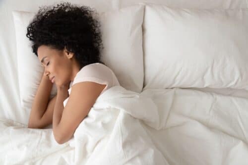 woman sleeps on white bedding scaled