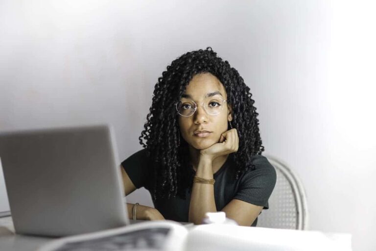 woman stares from behind her laptop