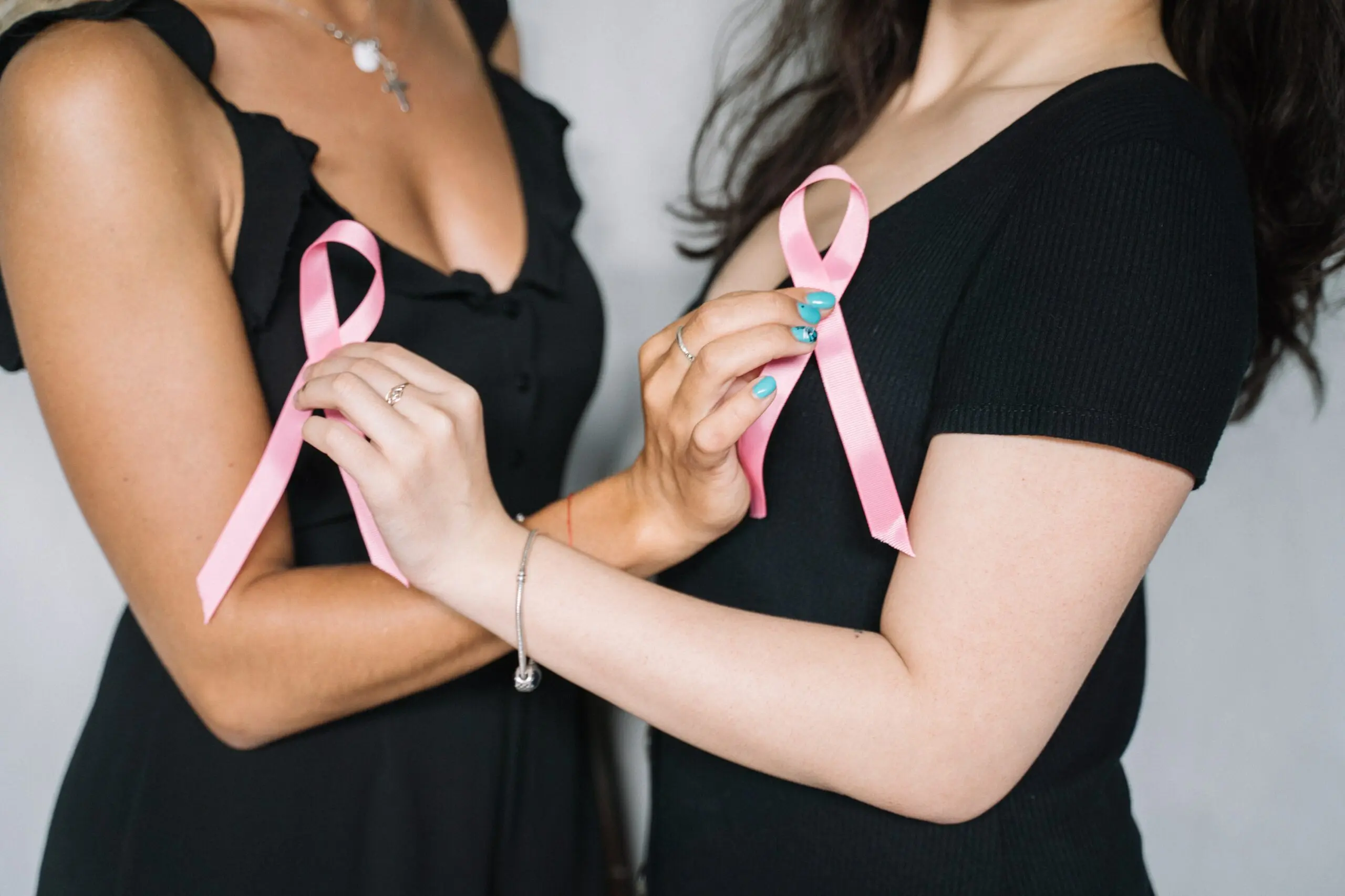 Women holding pink ribbons scaled