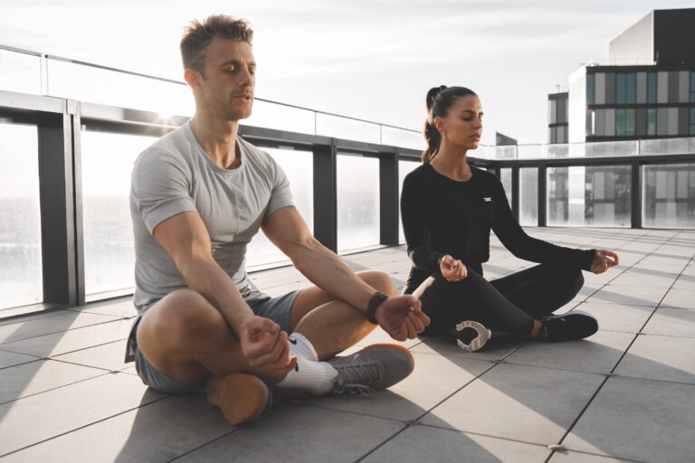 couple meditate on roof top