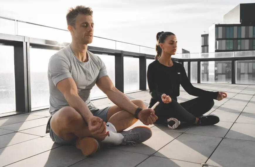 couple meditate on roof top