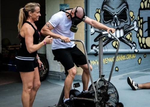 female coaching guy wearing gasmask