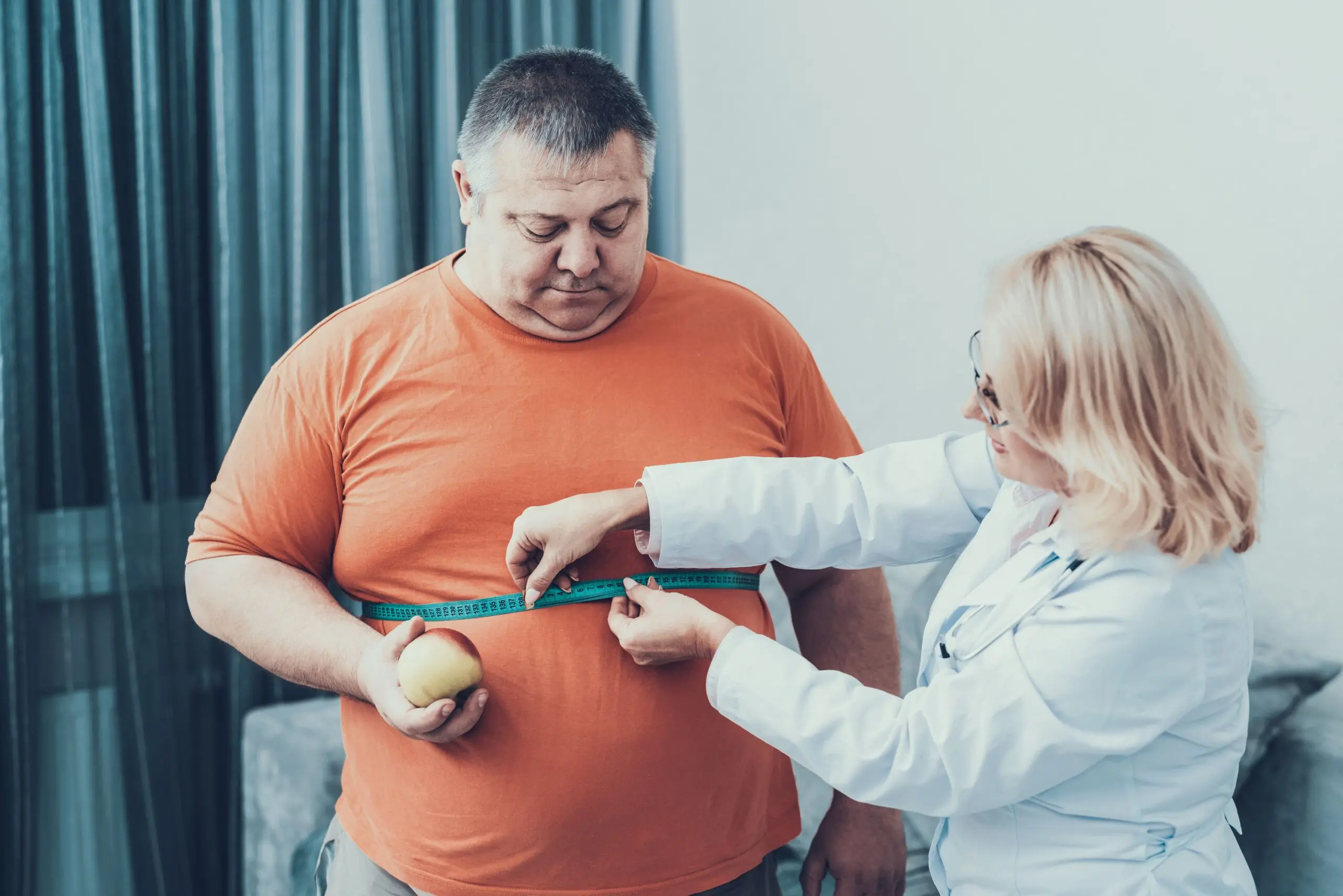 Large man having waist measured scaled