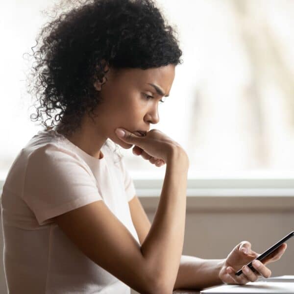 woman looking worried at phone scaled
