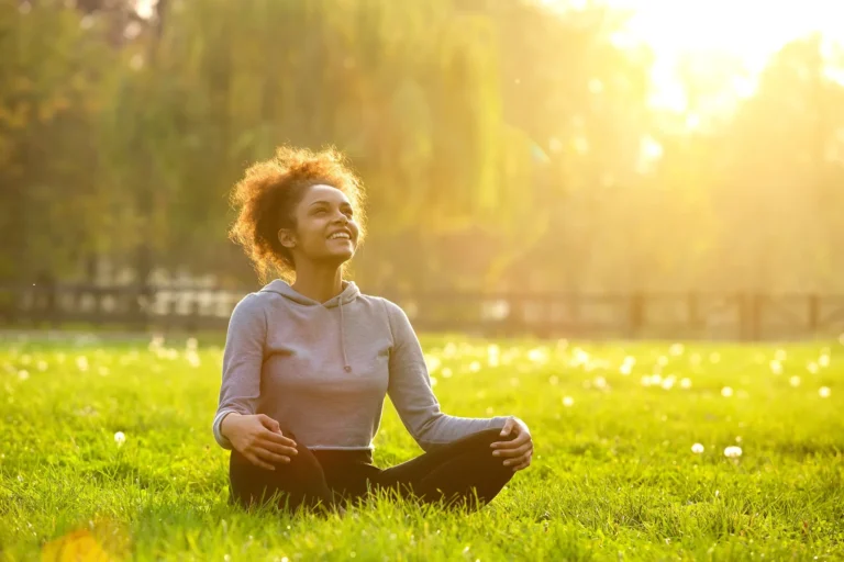 woman sits in field in the sunshine