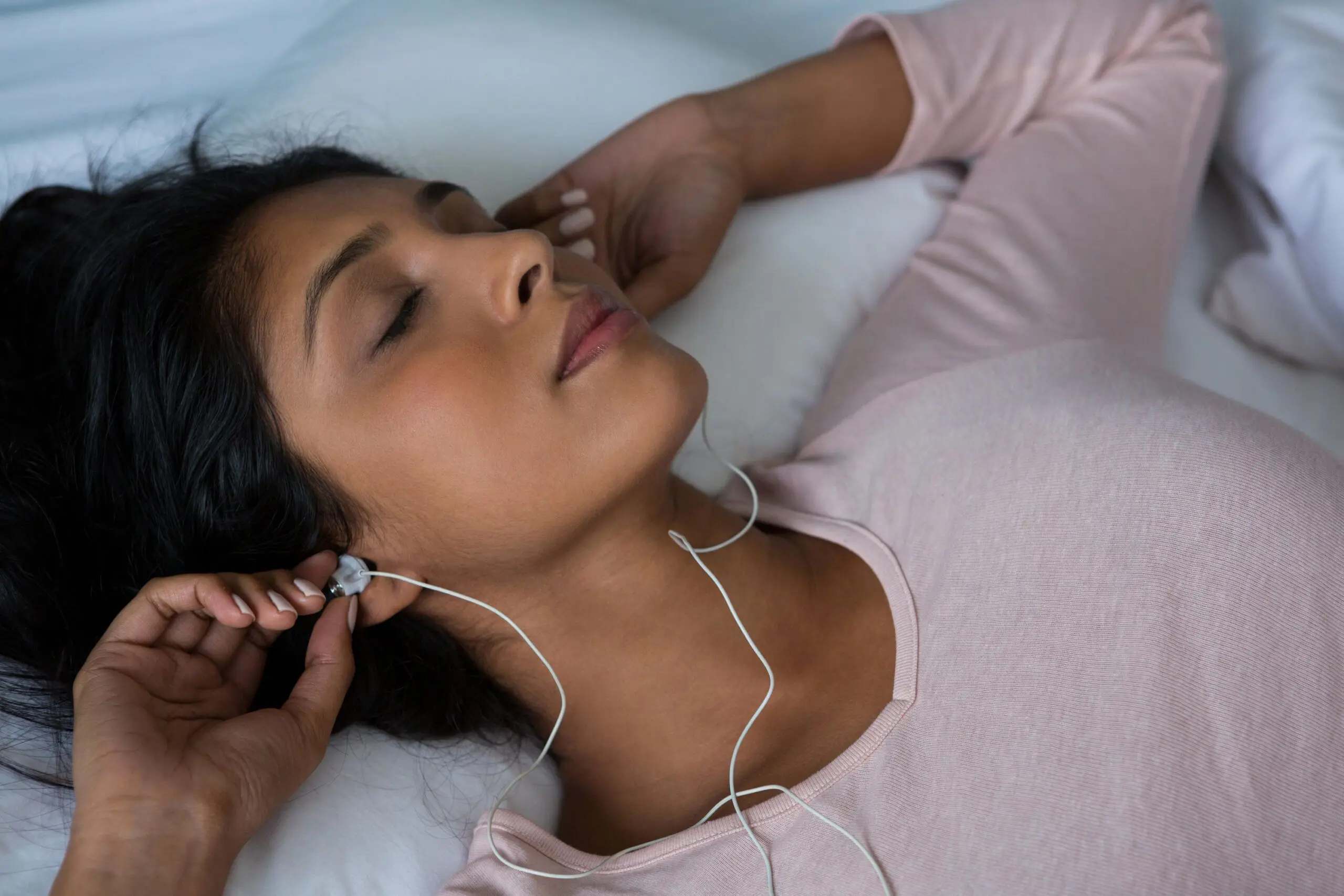 Woman sleeps with headphones in scaled