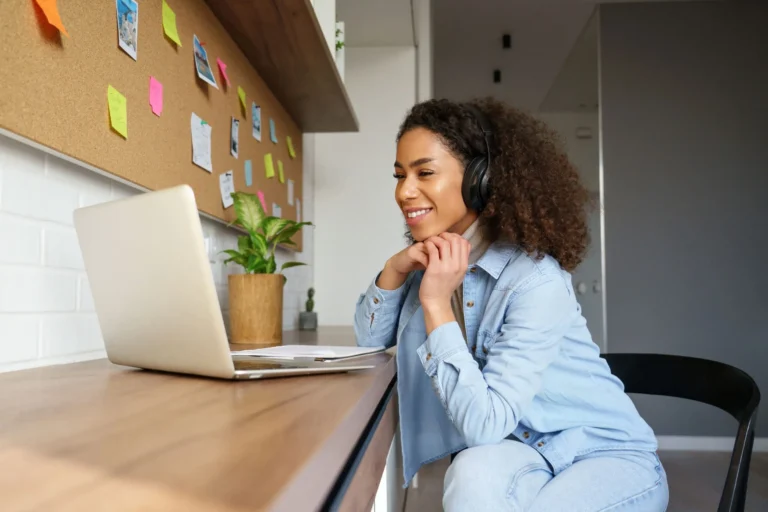 woman smiling while looking at laptop scaled