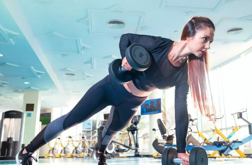 woman lifts dumbbell in gym scaled