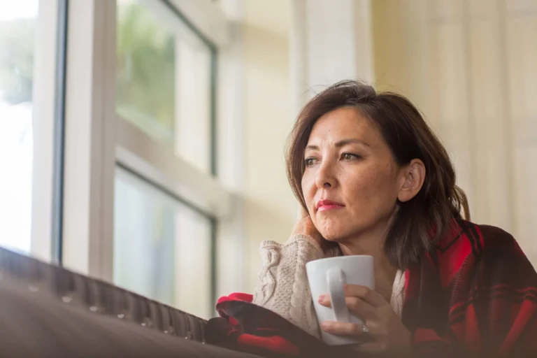 woman stares out of window scaled