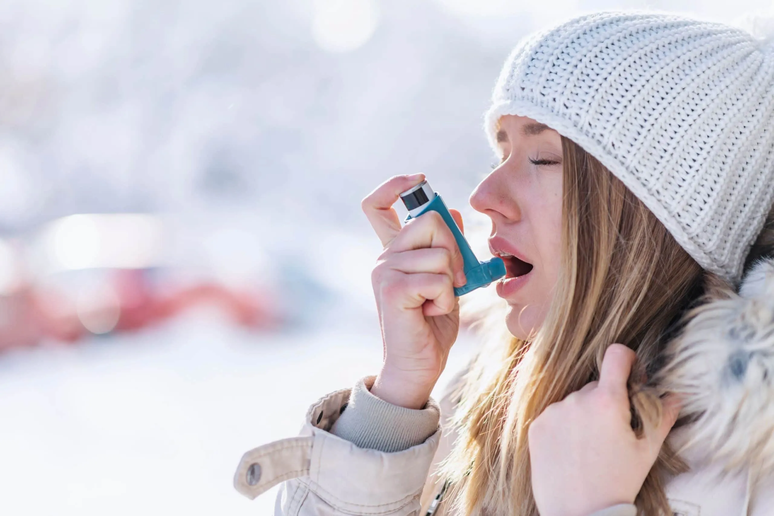woman uses asthma inhaler scaled