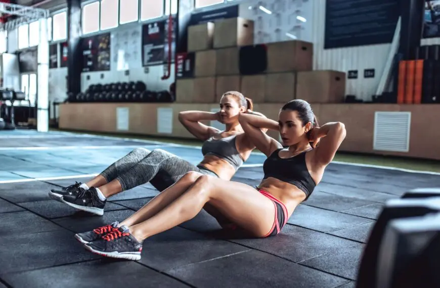 women perform crunches scaled