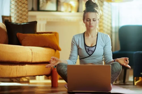 woman meditates in front of laptop scaled