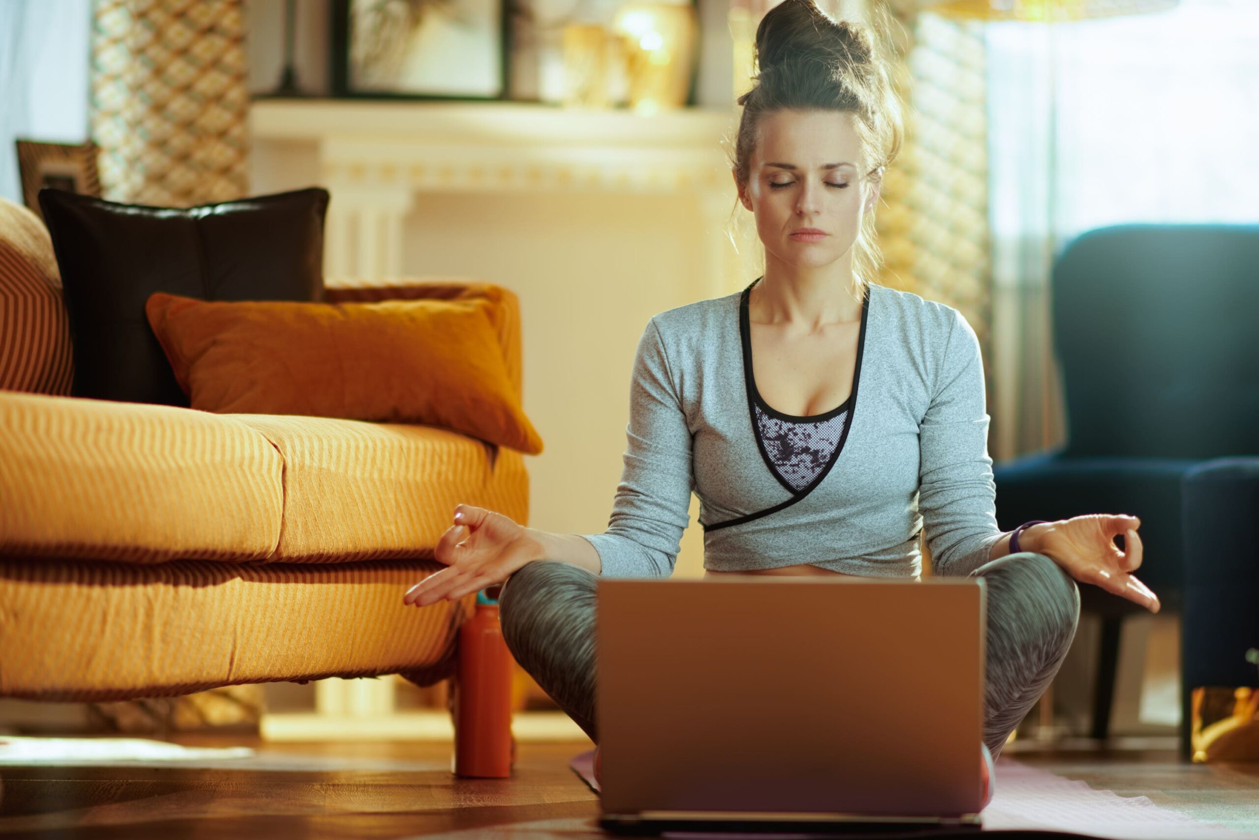 Woman meditates in front of laptop scaled