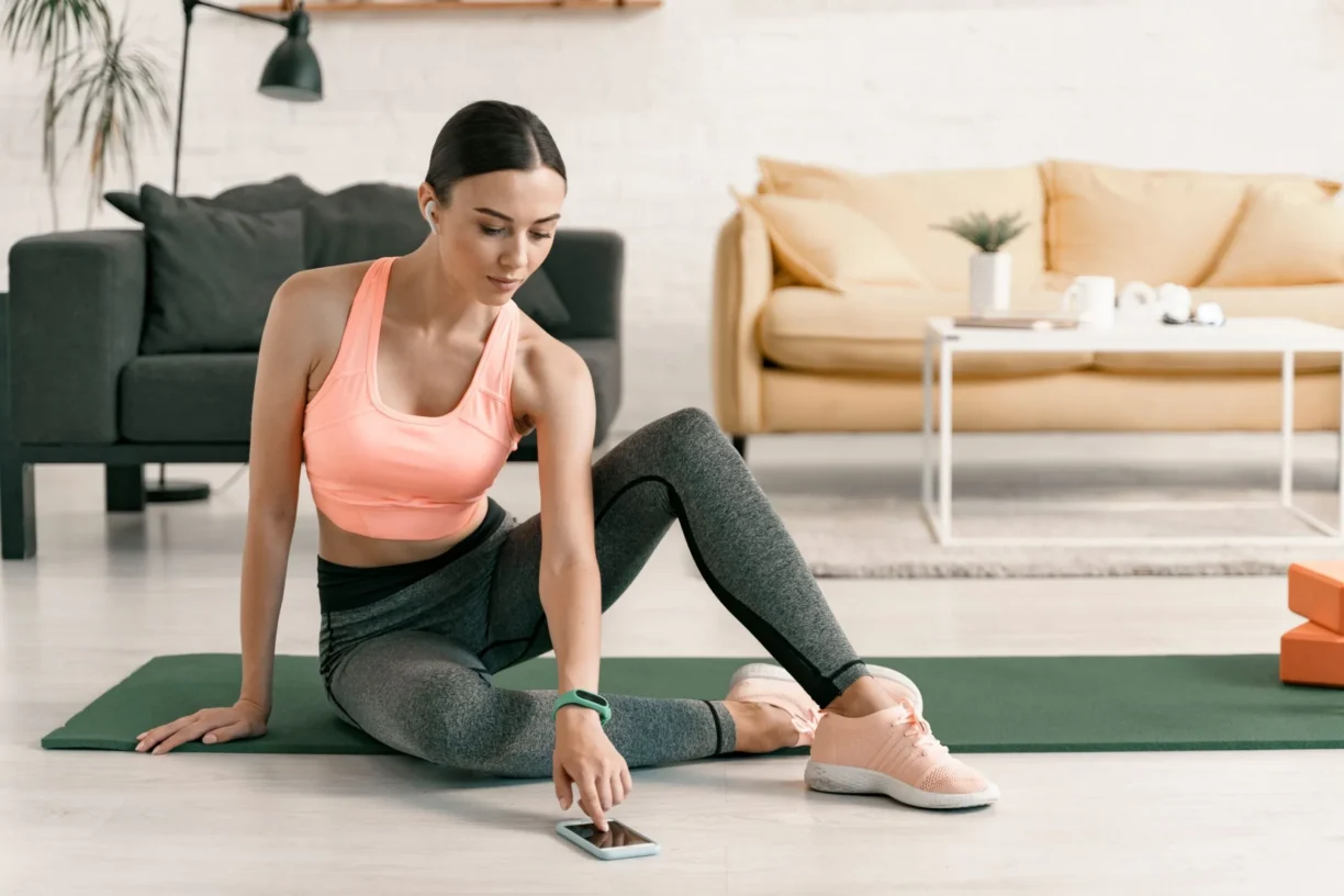 woman on yoga mat with phone app