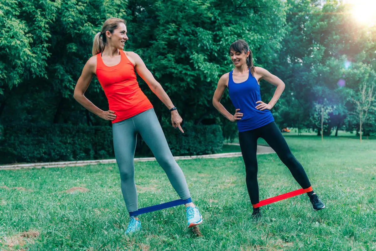 Women with resistance bands train outdoors