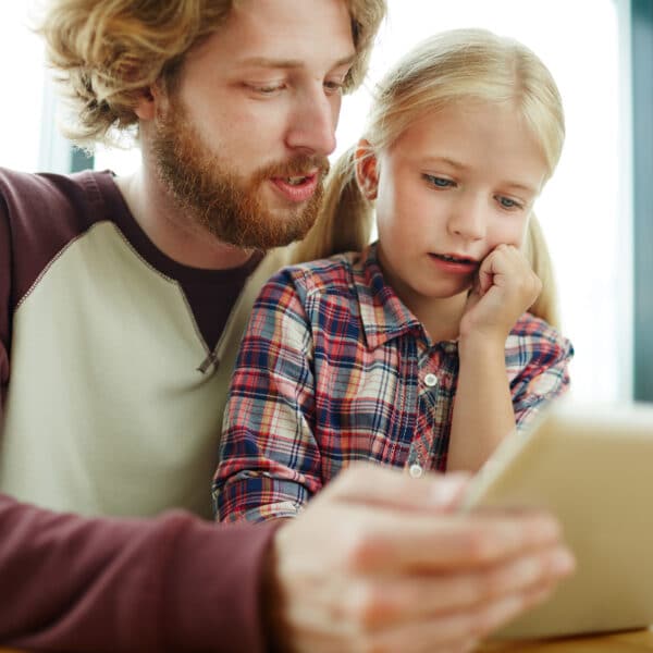 dad teaches daughter on tablet